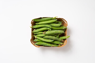 Overhead view of green peas pod in paper box