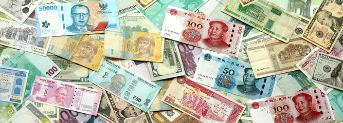 Many banknotes of different currency. Background of big amount of random money bills close up