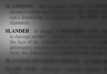 close up photo of the word slander - obrazy, fototapety, plakaty