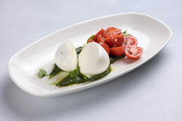 Caprese salad with mozzarella cheese, cherry tomatoes and basil