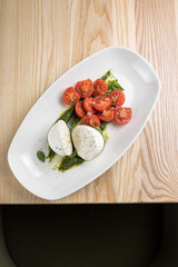 Caprese salad with mozzarella cheese, cherry tomatoes and basil