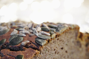 Close-up of homemade whole wheat bread cut with sunflower seeds, pumpkin.