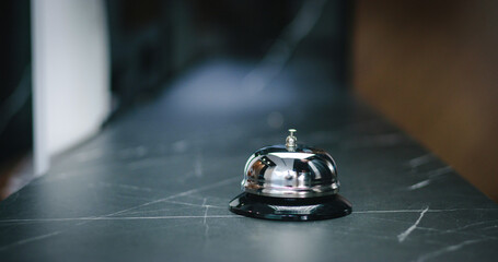 Ringing bell at front desk. Visitor and professional receptionist. Classy visitor getting hotel...