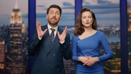 Two newsreaders discussing news standing stage tv studio closeup. Couple anchors