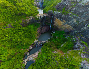 Canyon Oasis: Aerial View of Lush Greenery, Waterfall, and Rocky Cliffs