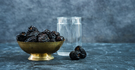 Iftar food background, glass of water with dates on the table, Ramadan fasting concept image