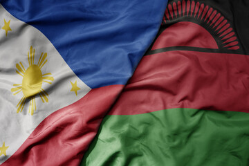 big waving national colorful flag of malawi and national flag of philippines.