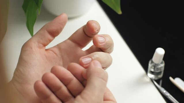 Rubbing manicure cuticle oil on nails and cuticles. Beautiful hands. Beauty care