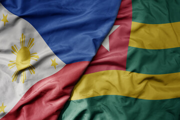 big waving national colorful flag of togo and national flag of philippines.