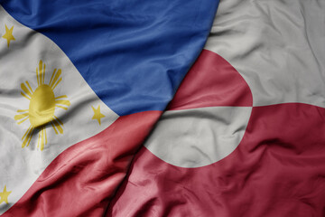 big waving national colorful flag of greenland and national flag of philippines.