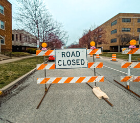 Road Closed Sign and Barricades on a City Street. Orange and white barricades with flashing lights...