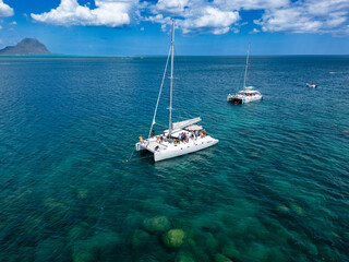 Aerial top view of a sailboat in a turquoise sea