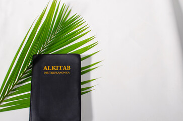 Holy Bible on Palm Leaves. Palm Sunday Concept. palms cross, holy bible and palm leaves, top view,...
