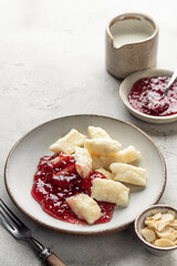 Lazy dumplings, vareniki with raspberry jam on white background. Boiled cottage cheese homemade gnocchi, text space
