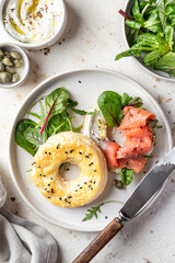 Homemade bagel sandwich with smoked salmon, cream cheese, capers and spinach for healthy breakfast top view