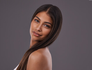 Naklejka premium Salon, hair and portrait of woman on gray background for healthy texture, wellness and beauty. Haircare, hairdresser and face of person with long hairstyle for products, cosmetics and shine in studio