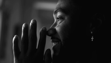 One happy young black man PRAYING in feeling HOPEFUL. Faithful African American person profile...