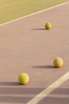 Tennis balls scattered on a hard court surface