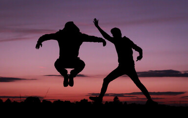 Silhouetten von Personen vor einem wunderschön bunten Himmel bei Abenddämmerung