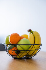 Fruit basket on the table in bright kitchen with blurred background for decoration
