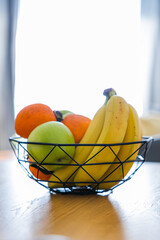 Fruit basket on the table in bright kitchen with blurred background for decoration
