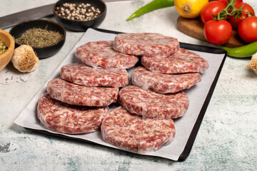 Hamburger Patty. Butcher products. Raw hamburger patties with gelatin on a stone background