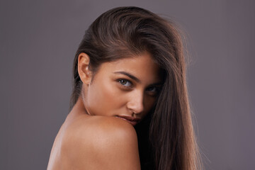 Naklejka premium Woman, studio and haircare with natural beauty, Indian female person with luxury and salon treatment. Nourishing and keratin blowout for results and wellness, confident and isolated glowing model