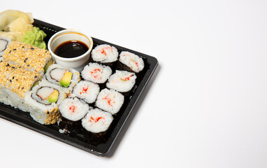 Sushi to go in a black takeaway box with wooden chopsticks on white background 