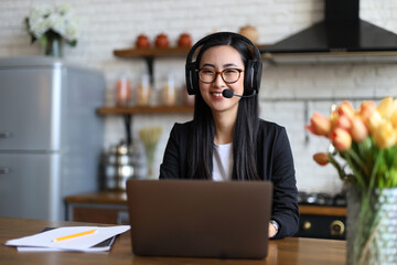 Asian businesswoman provides excellent customer service over the laptop with a headset.