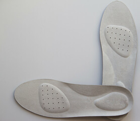 Leather orthopedic insoles on white background. Prevention and treatment of flat feet. Foot care.