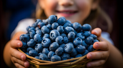 Close-up of a child holding a vibrant bunch of blueberries,