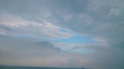 Obraz premium Photograph of a view of the sea, mountains, and sky with dense clouds gathering.