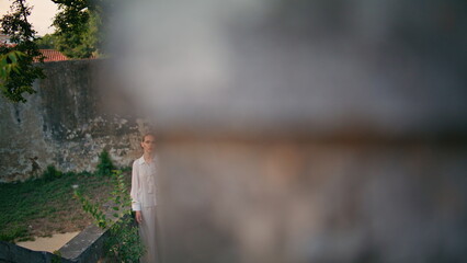 Woman tourist standing old castle leaning on fence. Girl posing at old building