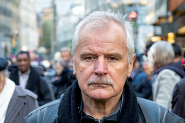 Portrait of senior citizen in a crowded street.