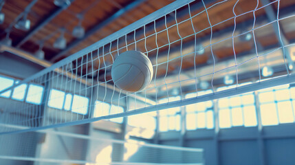 Closeup of the white volleyball sport ball flying in the air towards the net in the arena interior....