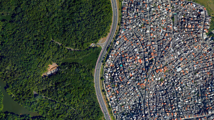 Forest and city border and road, forest and city separated by an s-shaped line, looking down aerial...