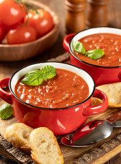 Bowl of tomato soup garnished with basil leaves