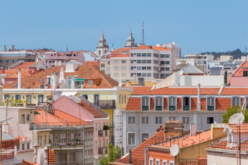Fototapeta na wymiar Cityscape of colorful traditional houses in Lisbon historic center, Portuguese red rooftops, balconies, antenna, and construction, Portugal