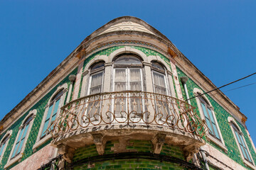 Vintage Portuguese green tiles façade of an old house in Lisbon with an old vintage iron balcony. Old traditional architecture house in historic center of Lisbon Portugal.