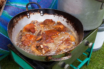 Photograph of pork frying in hot oil to prepare Peruvian chicharron. Peruvian food concept.