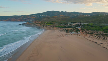 Wonderful evening beach seascape with coast washed by foamy blue ocean waves