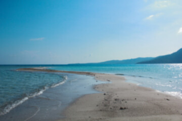 Blurred photo of white sand island beach and blue sky. Beautiful scenery background.