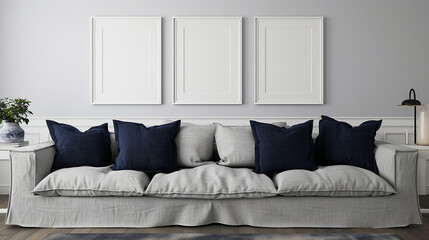 A modern living room with a gray linen sofa, navy blue pillows, and three empty white frames mockup