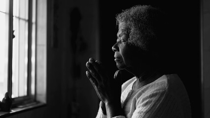 Spiritual African American Elderly Lady in Deep Meditation, Black and White Home Prayer by window
