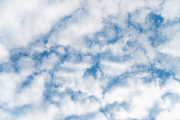 Elegant white clouds and blue sky background. Clouds spreading on the sky in sunny day. Glowing white clouds on the blue sky. Cumulus clouds with deep blue sky. Nature concept background