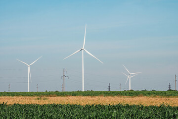 Windfarms with rotor blades spinning pole at top on unoccupied sites. Countryside field with wind...