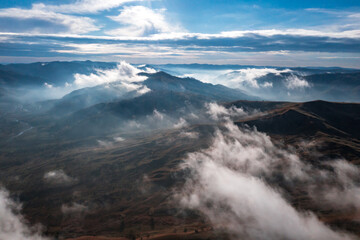 Morning view with mountain village and fog an clouds in Romania
