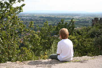 Naklejka na ściany i meble August 12, 2005. Healthy lifestyle. Boy sitting on a stone path looking at the view...