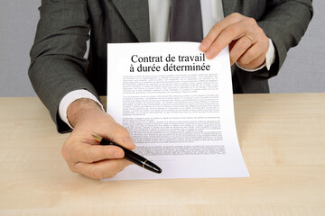 Concept de contrat de travail à durée déterminée présenté par un employeur avec un stylo pour...