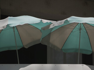 two mint and gray colored parasol covering a balcony 